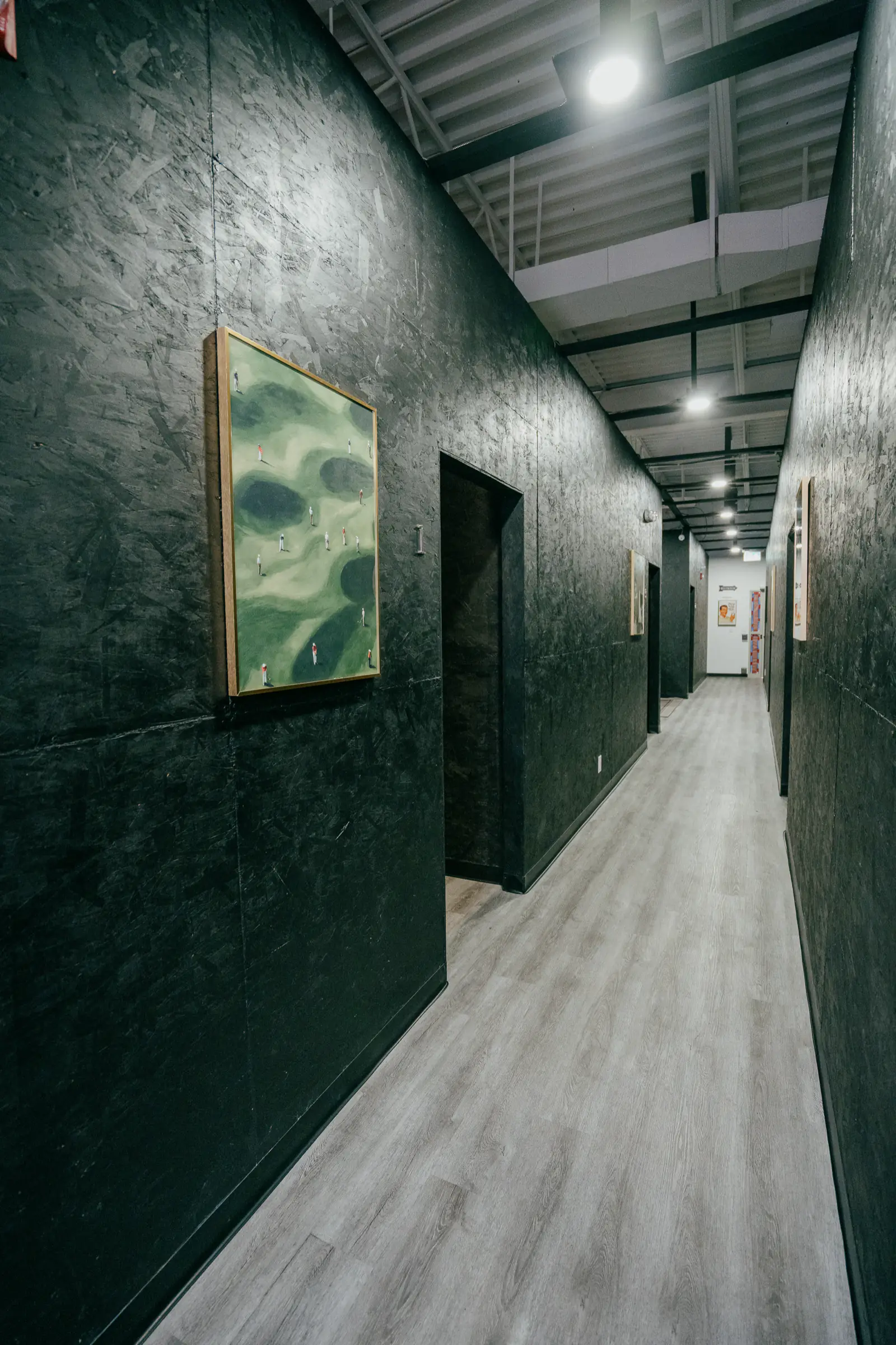 The hallway at PGM Indoor Golf Calgary, with doors leading to the private simulator bays