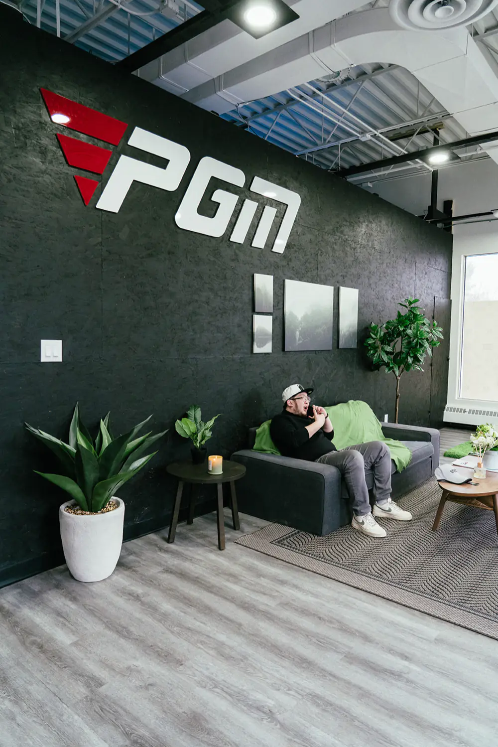 The lounge sofa and the red and white PGM logo wall, seen from the side
