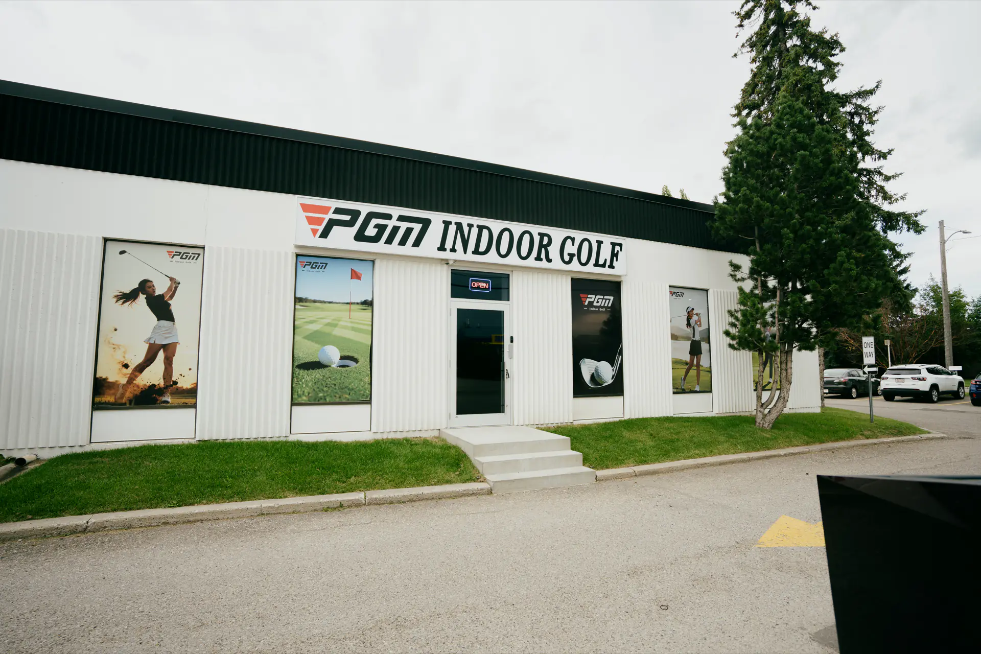 The PGM Indoor Golf storefront in SE Calgary, with the sign above the door and golf graphics in the windows