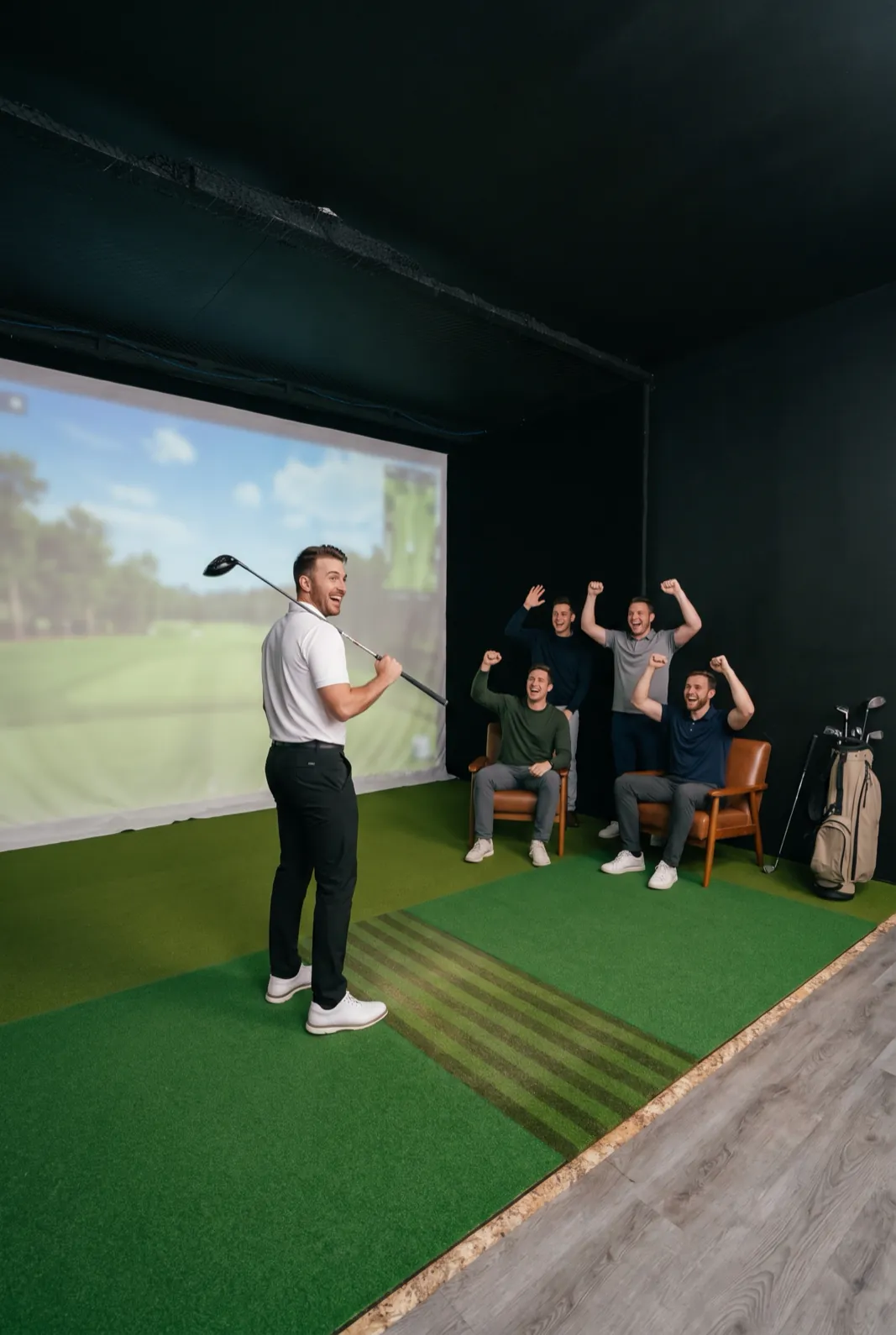 A golfer turns from the hitting mat to four friends cheering beside the bay seating